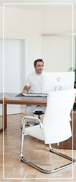 Bild von der Sprechstunde mit Dr. George Heinz, wie er vor seinem Computer sitzt.