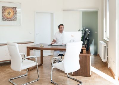Dr. Heinz sitzt im Besprechungszimmer vor seinem Computer